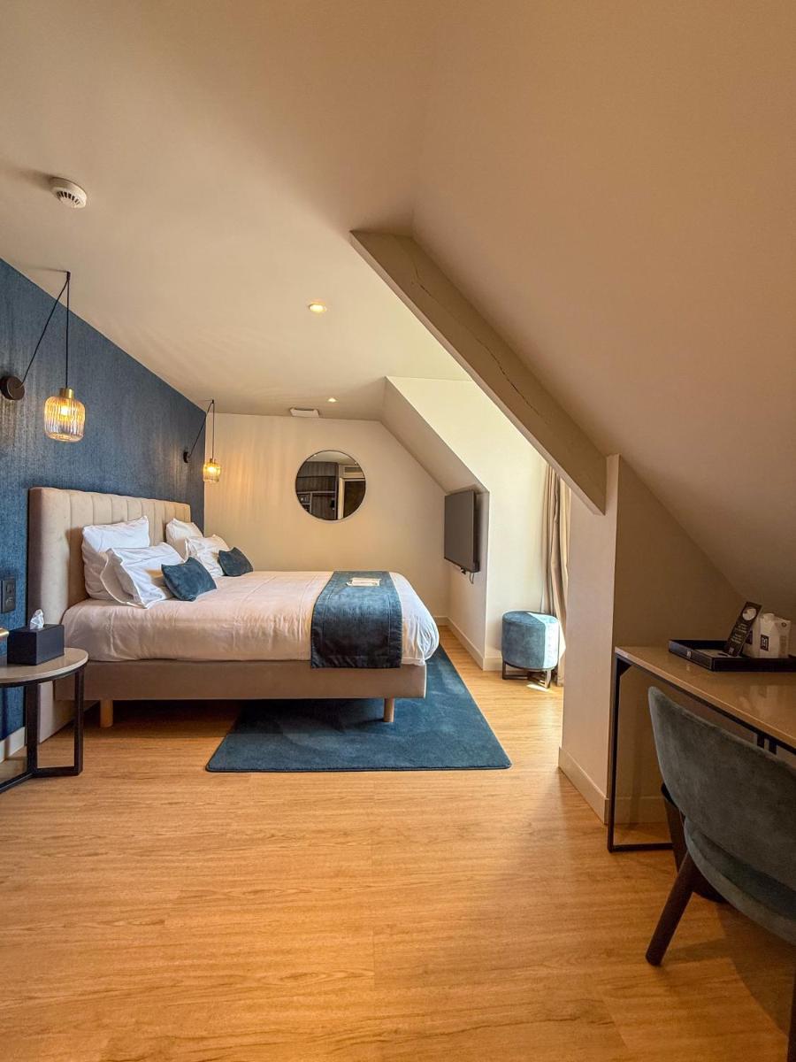une chambre avec un grand lit dans un grenier dans l'établissement Hôtel & Spa Le Maury, Vannes, The Originals Boutique, à Vannes