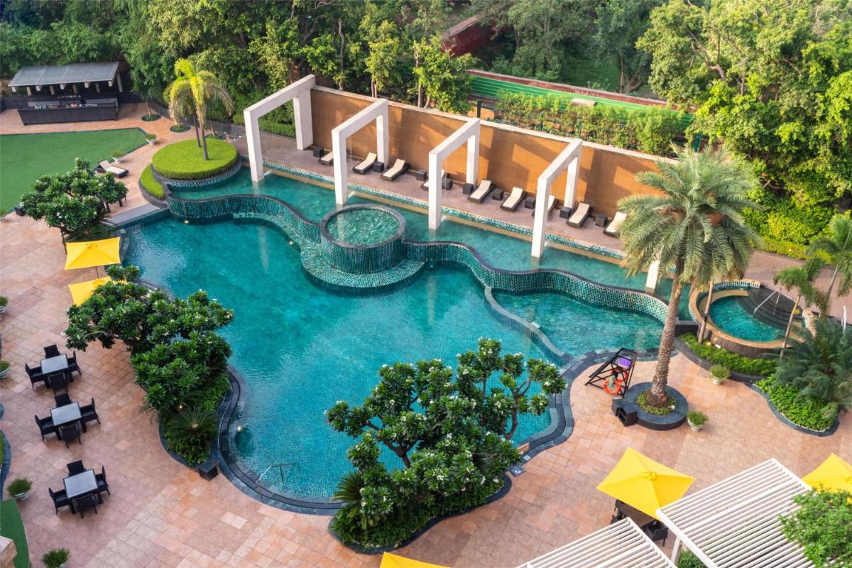an aerial view of a swimming pool at a resort at Radisson Blu Plaza Delhi Airport in New Delhi an aerial view of a swimming pool at a resort at Radisson Blu Plaza Delhi Airport in New Delhi