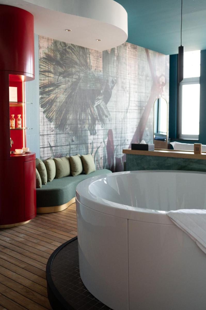 une salle de bain avec une baignoire blanche dans une chambre dans l'établissement Hotel Atlantic, à Wimereux