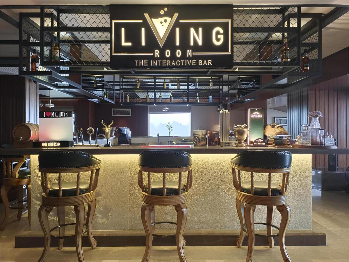 a bar with two bar stools in a restaurant at Radisson Kufri in Shimla
