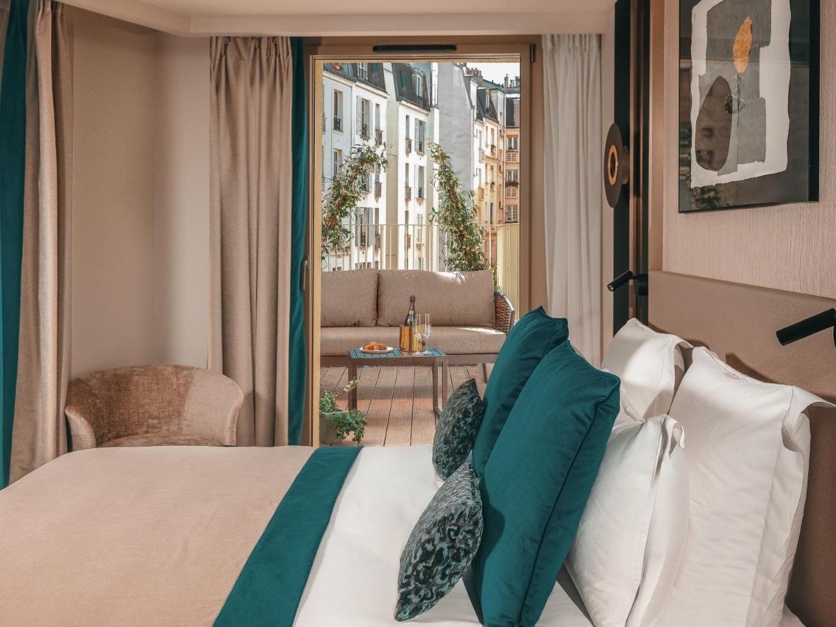une chambre d'hôtel avec un lit et un balcon dans l'établissement Hôtel Barnett Paris, à Paris