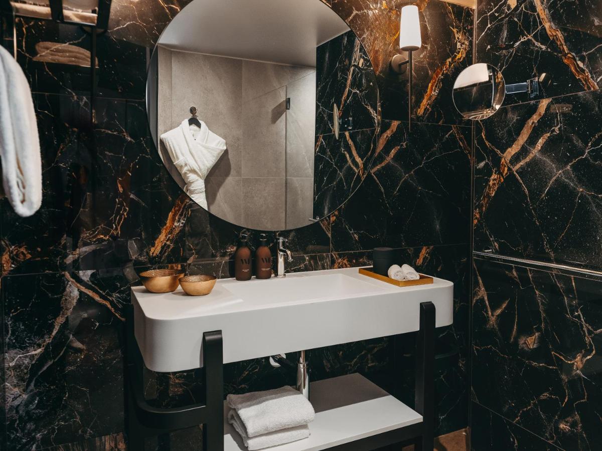 une salle de bain avec un lavabo blanc et un miroir dans l'établissement Hôtel Barnett Paris, à Paris