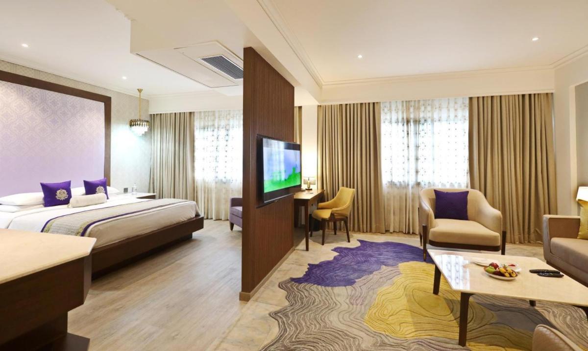 a hotel room with a bed and a tv at Vivanta Bengaluru Residency Road in Bengaluru a hotel room with a bed and a tv at Vivanta Bengaluru Residency Road in Bengaluru