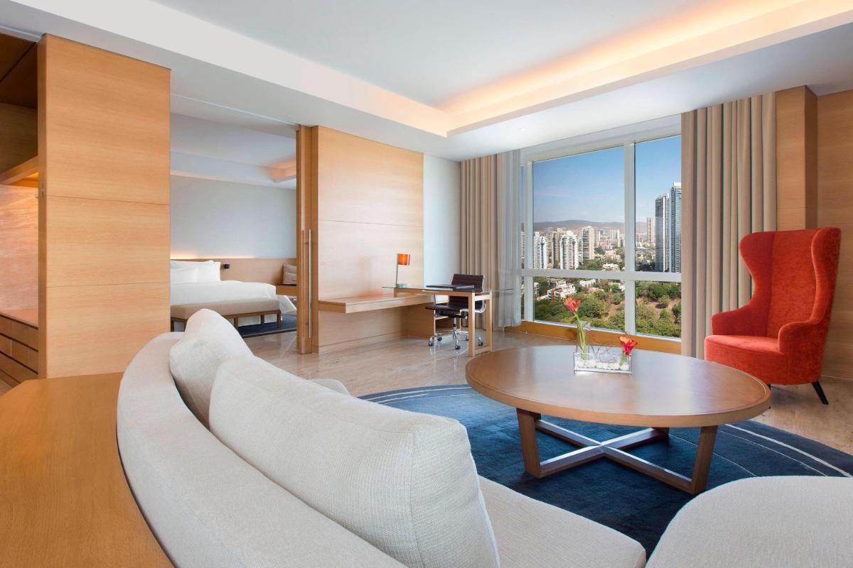 a hotel room with a couch and a table at The Westin Mumbai Garden City in Mumbai