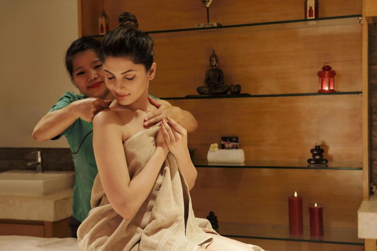 a woman getting her hair washed in a bathroom at Four Points by Sheraton Hotel and Serviced Apartments Pune in Pune
