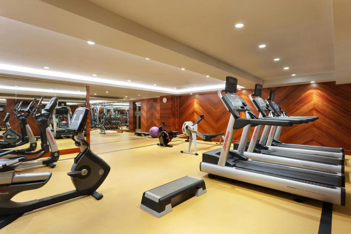 a gym with treadmills and elliptical machines at Sheraton Grand Pune Bund Garden Hotel in Pune