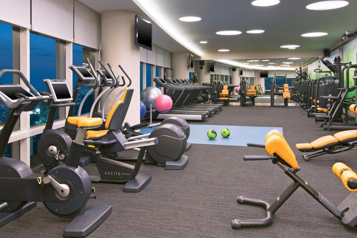 a gym with many treadmills and exercise machines at The Westin Mumbai Garden City in Mumbai