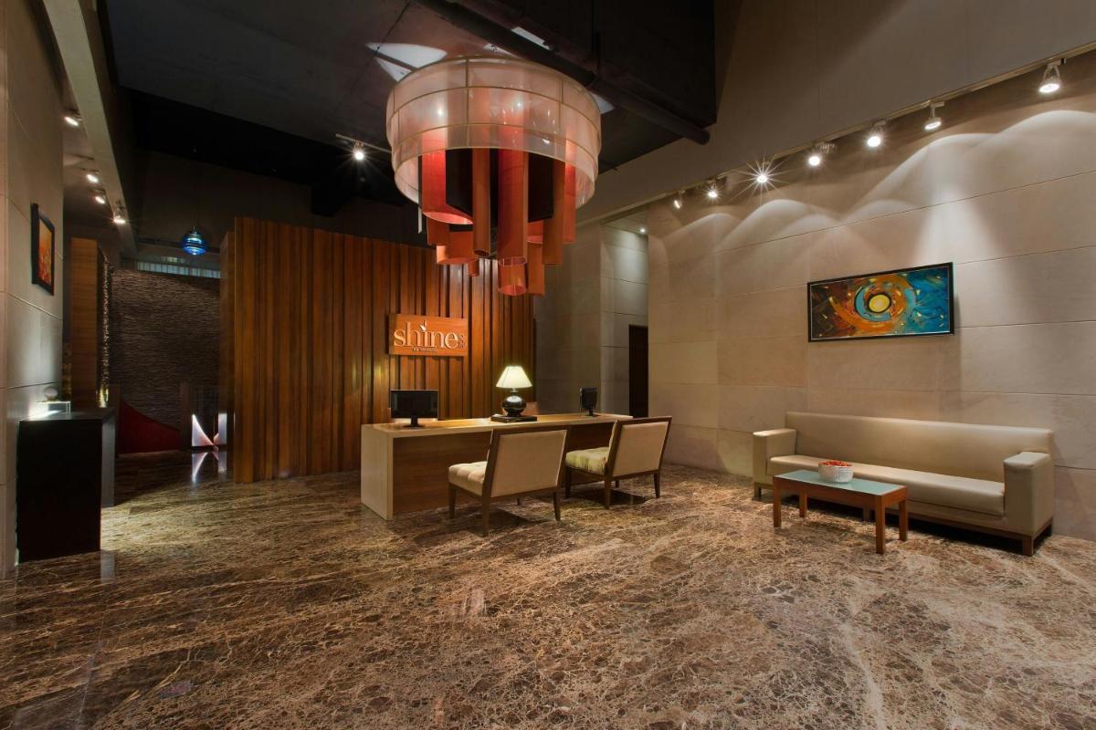 a lobby with a couch and a table and a chandelier at Sheraton Grand Bangalore Hotel at Brigade Gateway in Bengaluru