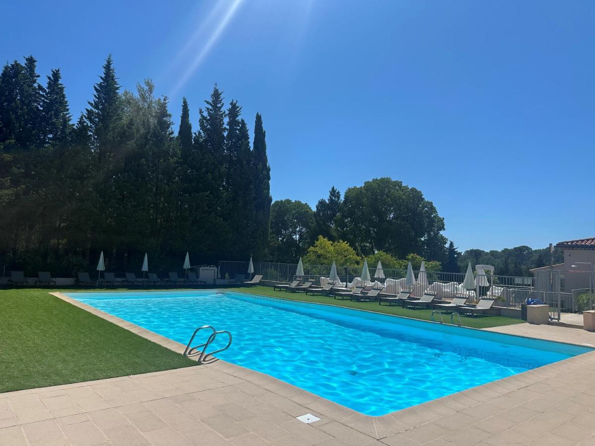 une piscine avec des chaises longues et une piscine dans l'établissement Hôtel Golf & Spa Château de la Bégude The Originals Collection, à Valbonne
