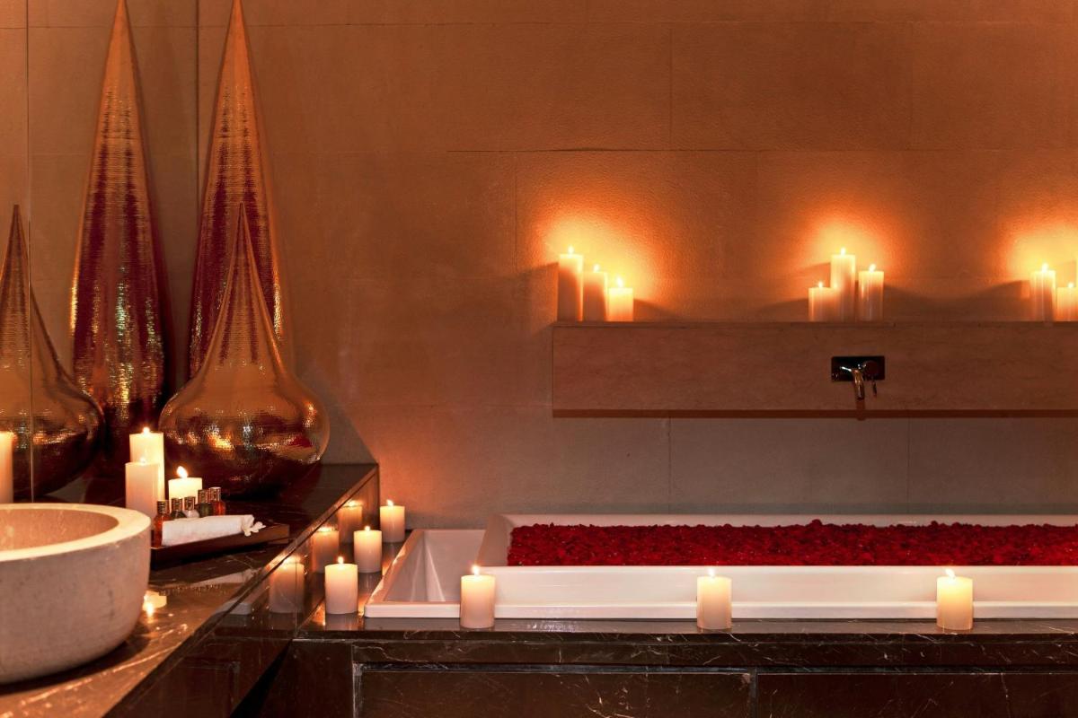 a bathroom with candles and a counter with red roses at The Westin Gurgaon, New Delhi in Gurgaon
