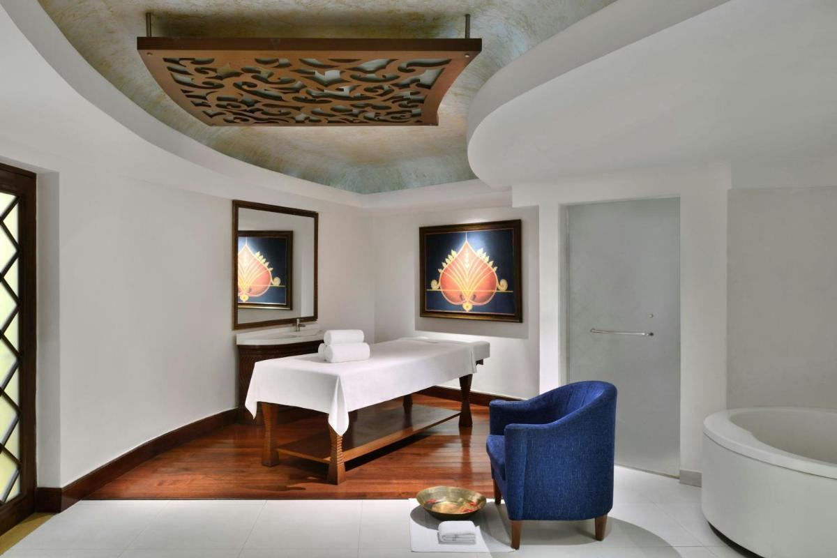 a living room with a white table and a blue chair at Le Meridien New Delhi in New Delhi a living room with a white table and a blue chair at Le Meridien New Delhi in New Delhi