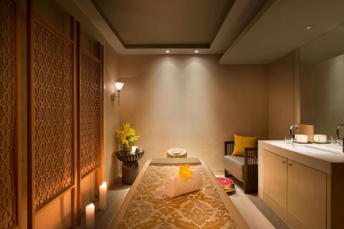 a living room with a table and a kitchen at Sheraton Hyderabad Hotel in Hyderabad
