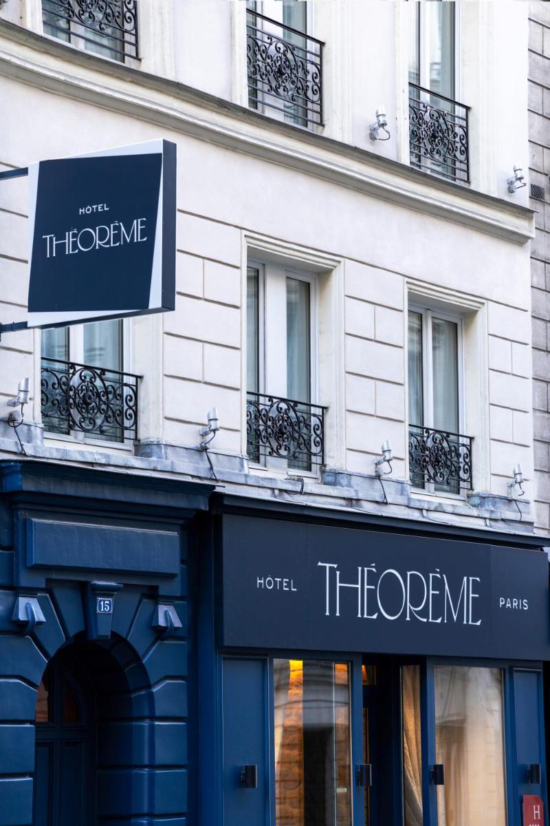 un magasin avec une enseigne sur le côté d'un bâtiment dans l'établissement Hôtel Théorème, à Paris