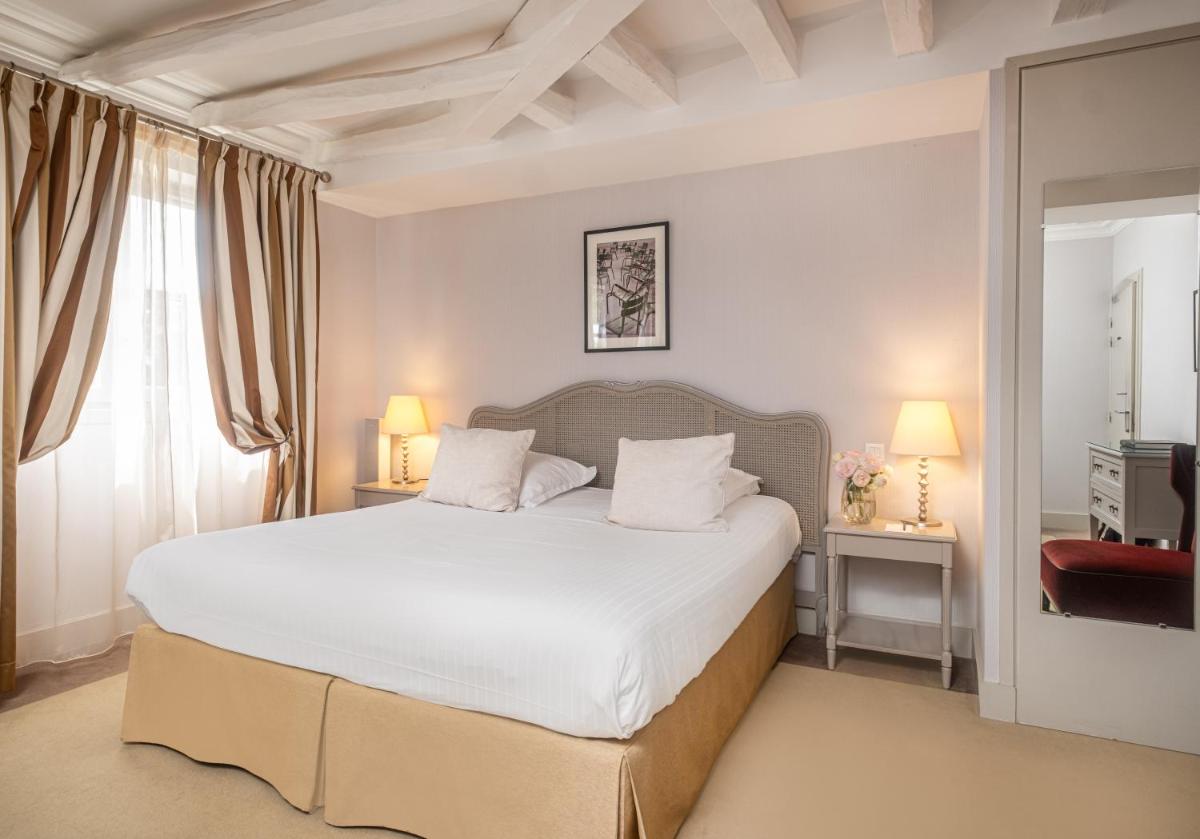 une chambre avec un grand lit blanc et une fenêtre dans l'établissement Château Belmont Tours by The Crest Collection, à Tours