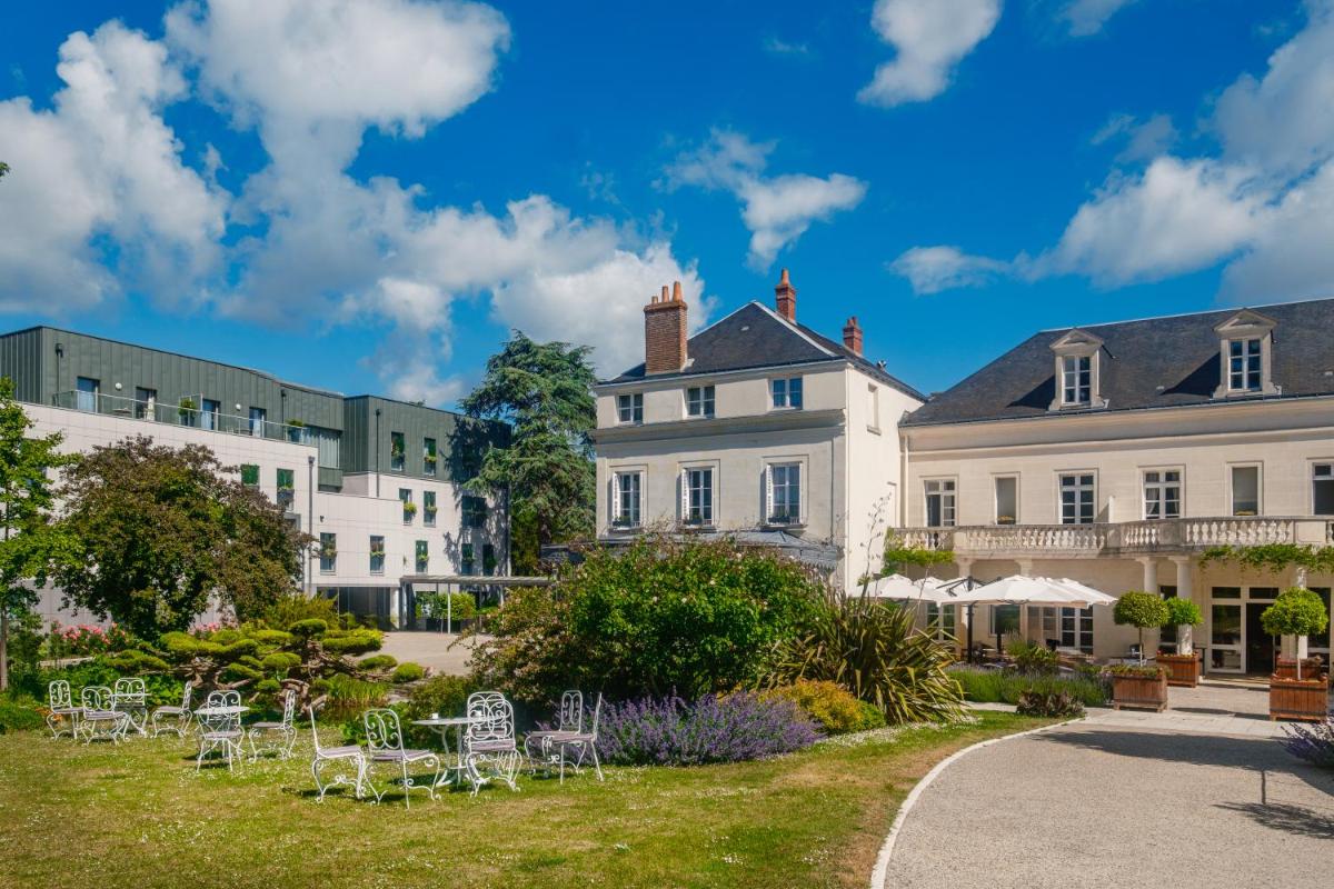 une rangée de bâtiments blancs avec des chaises dans une cour dans l'établissement Château Belmont Tours by The Crest Collection, à Tours