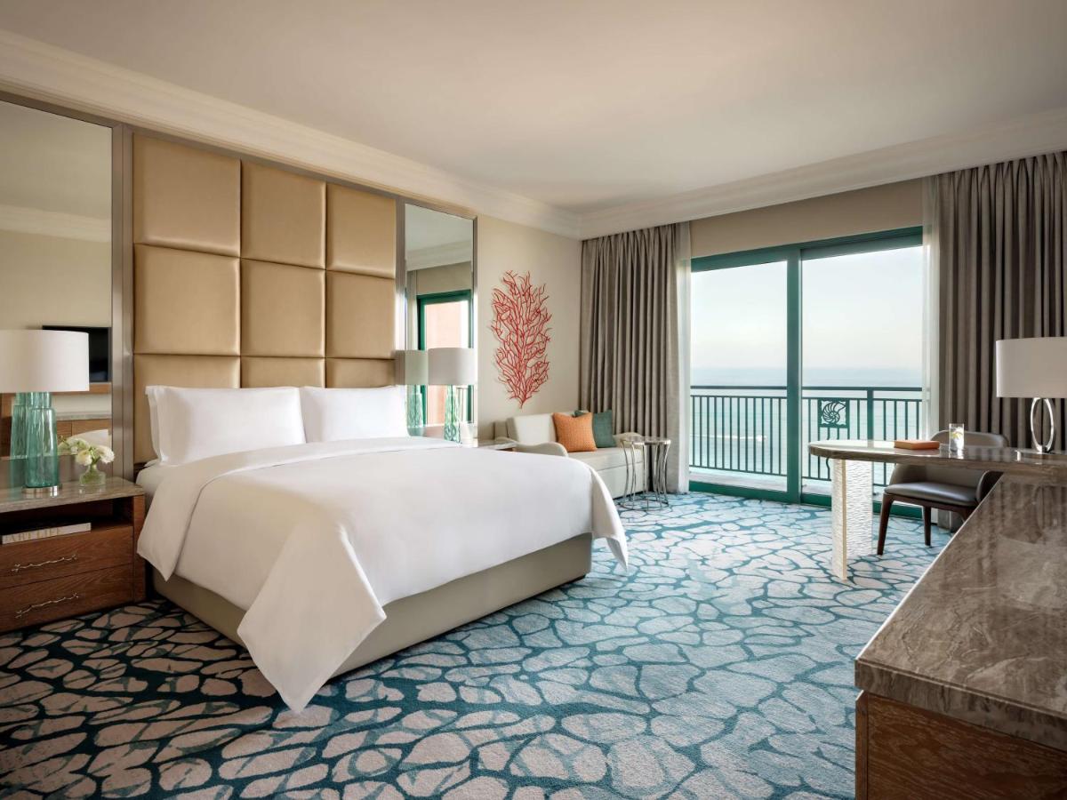 a bedroom with a large white bed and a balcony at Atlantis, The Palm in Dubai