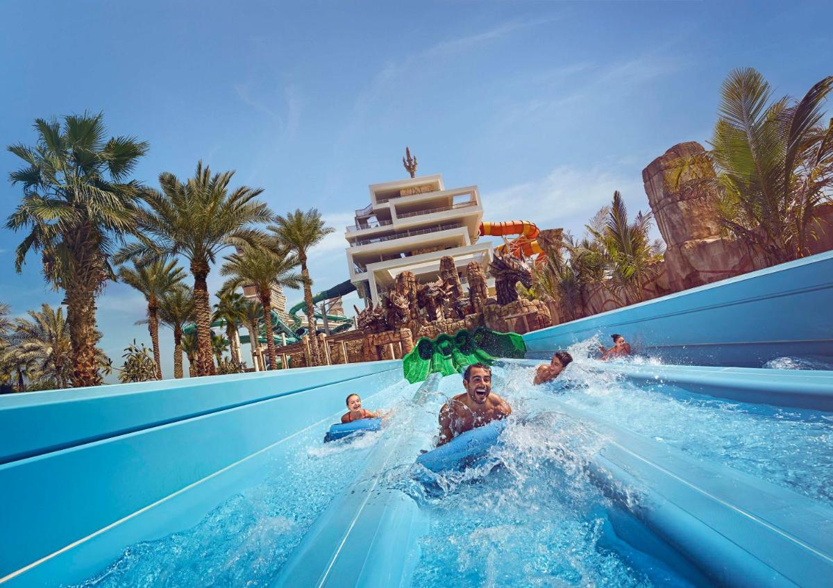 a group of people riding a water slide at a resort at Atlantis, The Palm in Dubai