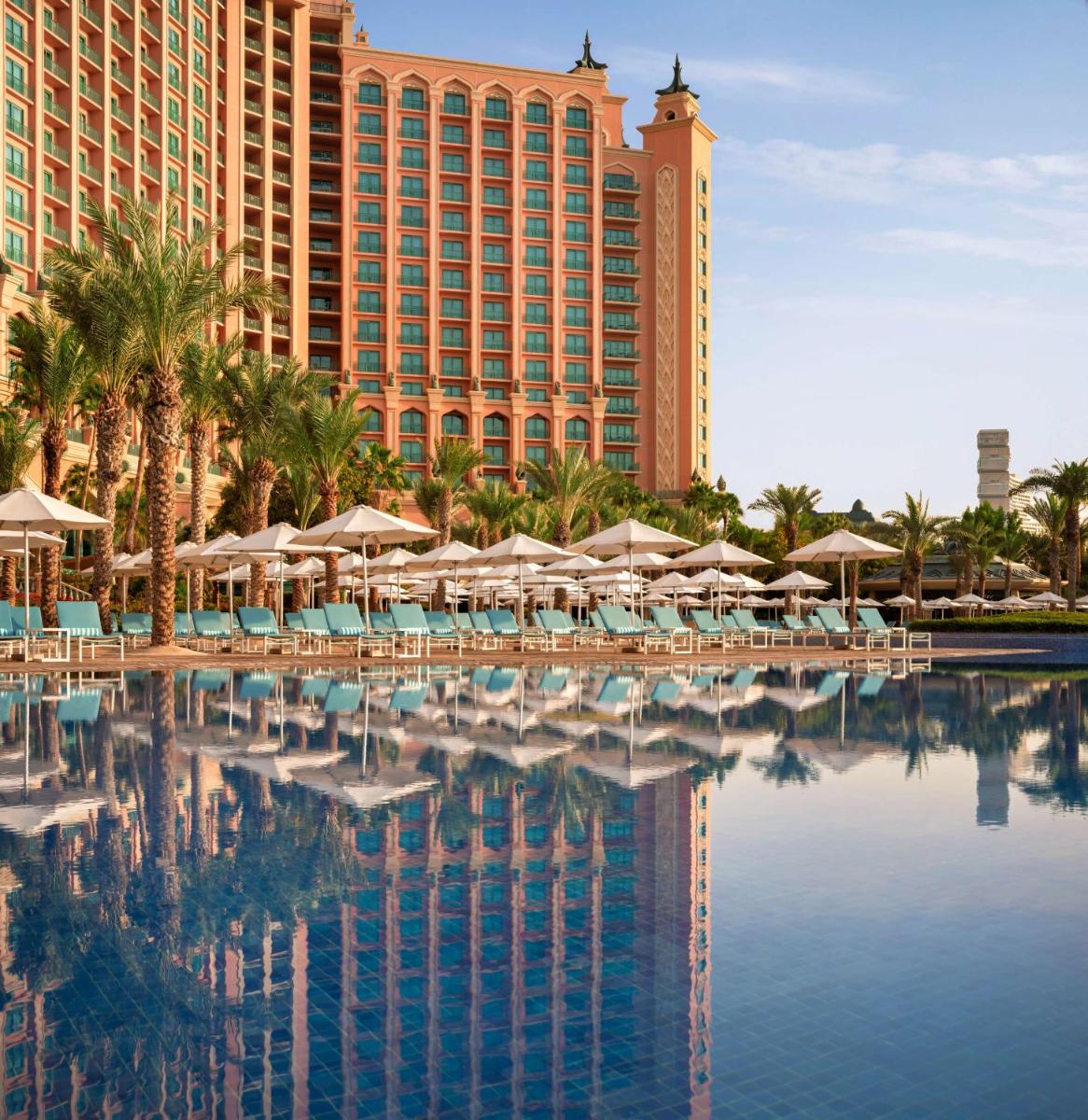 a resort with a pool with chairs and umbrellas at Atlantis, The Palm in Dubai