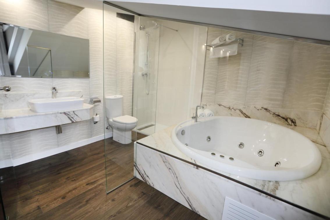Un baño con bañera, lavabo e inodoro. en Hotel Spa San Marcos, en Santillana del Mar