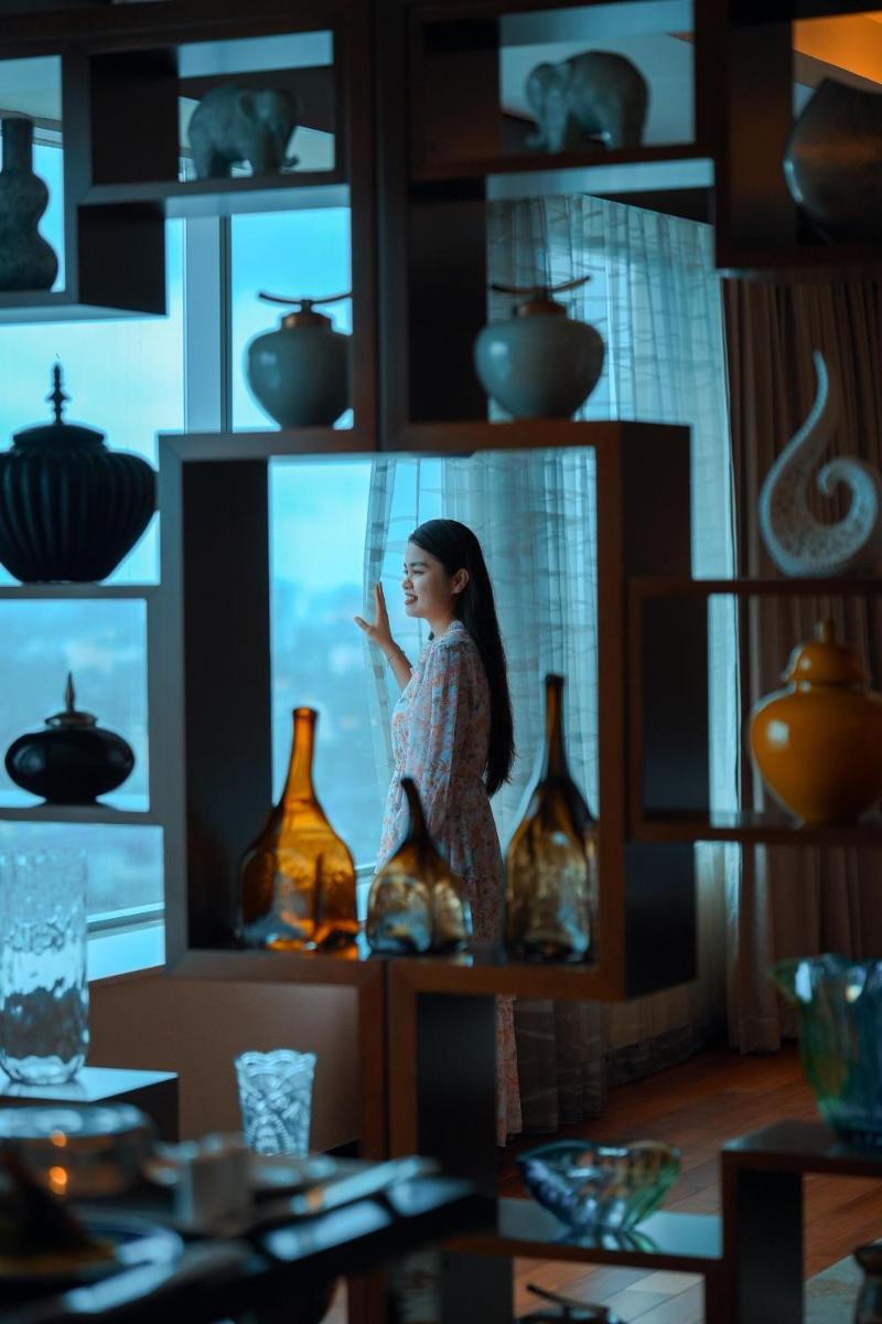 a woman standing on top of a shelf with vases at Kochi Marriott Hotel in Cochin