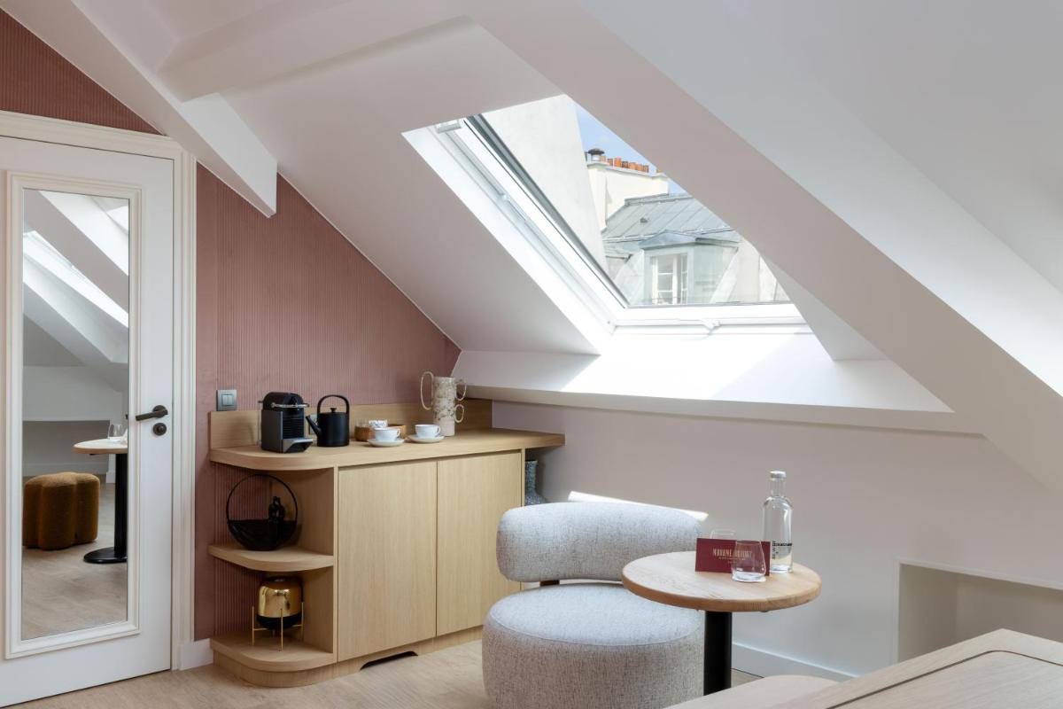 une pièce avec une chaise, une table et une fenêtre dans l'établissement Madame Drouot & Spa - Opera, à Paris