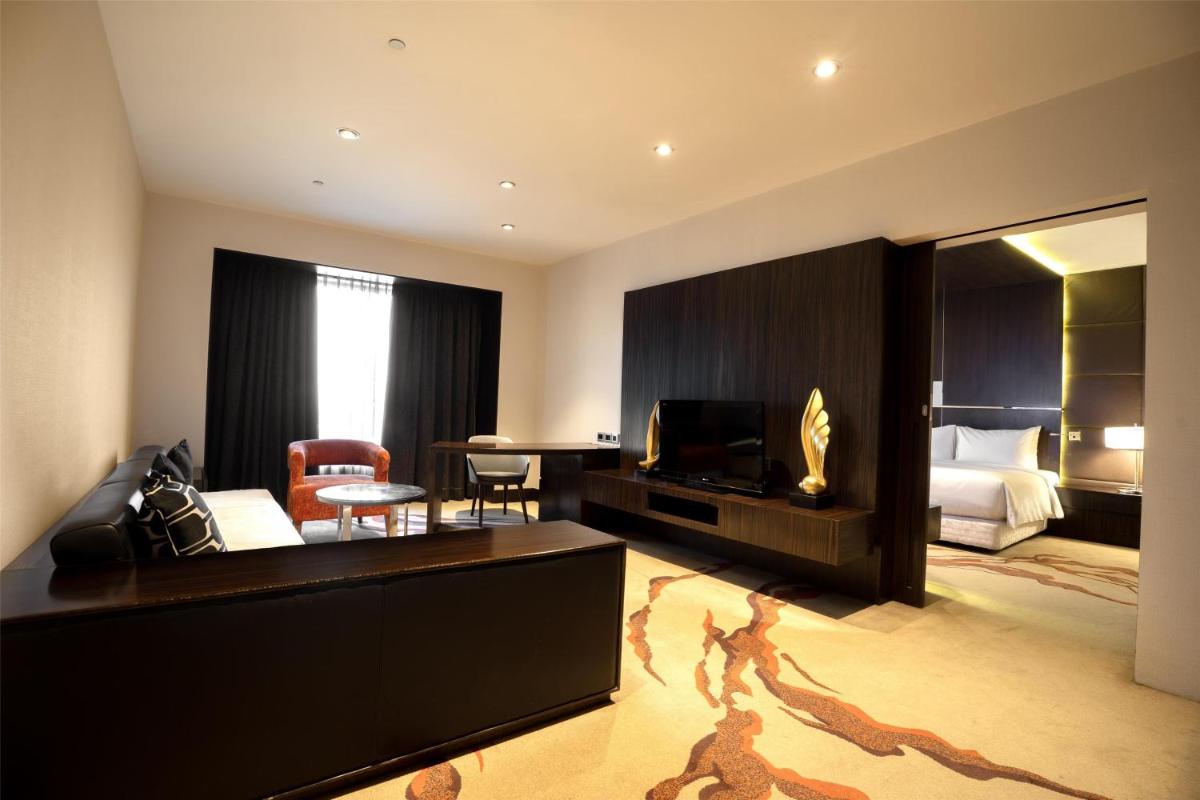 a hotel room with a bedroom and a living room at Radisson Blu Hotel Amritsar in Amritsar