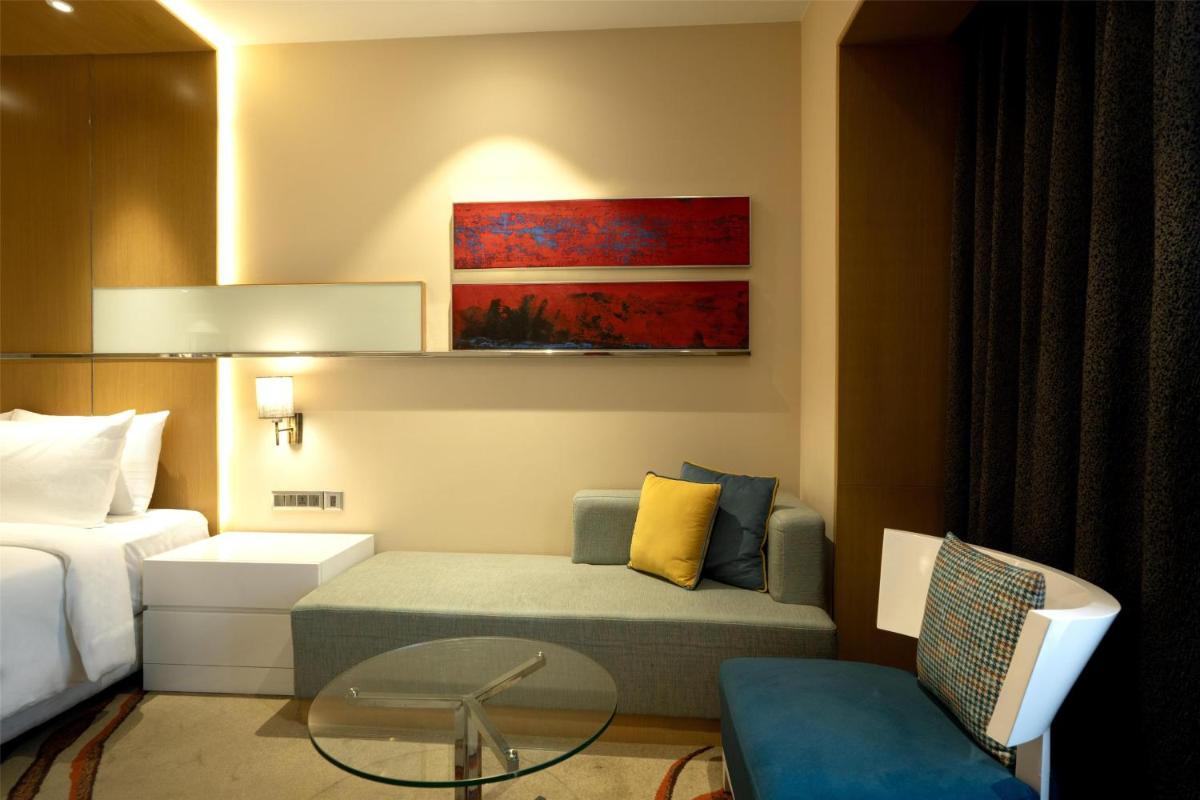 a hotel room with a bed and a couch and a table at Radisson Blu Hotel Amritsar in Amritsar