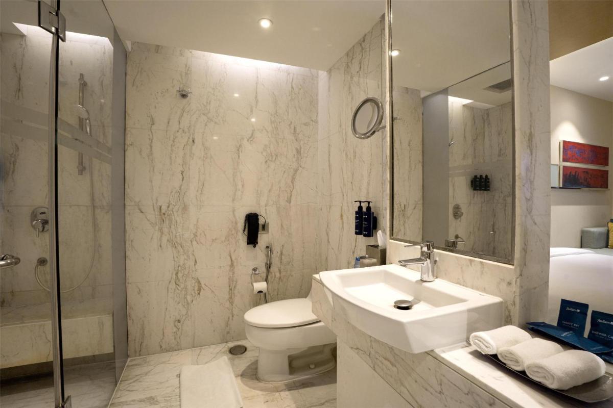 a bathroom with a sink and a toilet and a shower at Radisson Blu Hotel Amritsar in Amritsar