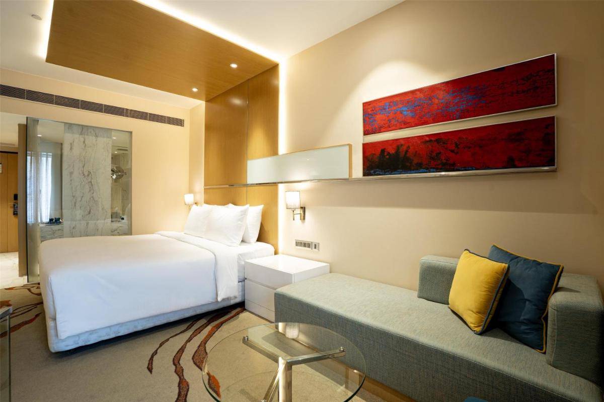 a hotel room with a bed and a couch at Radisson Blu Hotel Amritsar in Amritsar