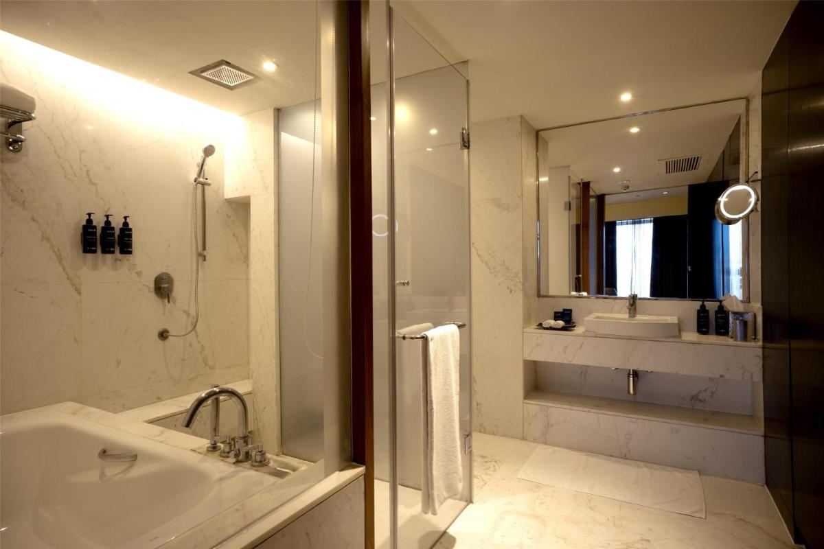 a bathroom with a tub and a shower and a sink at Radisson Blu Hotel Amritsar in Amritsar