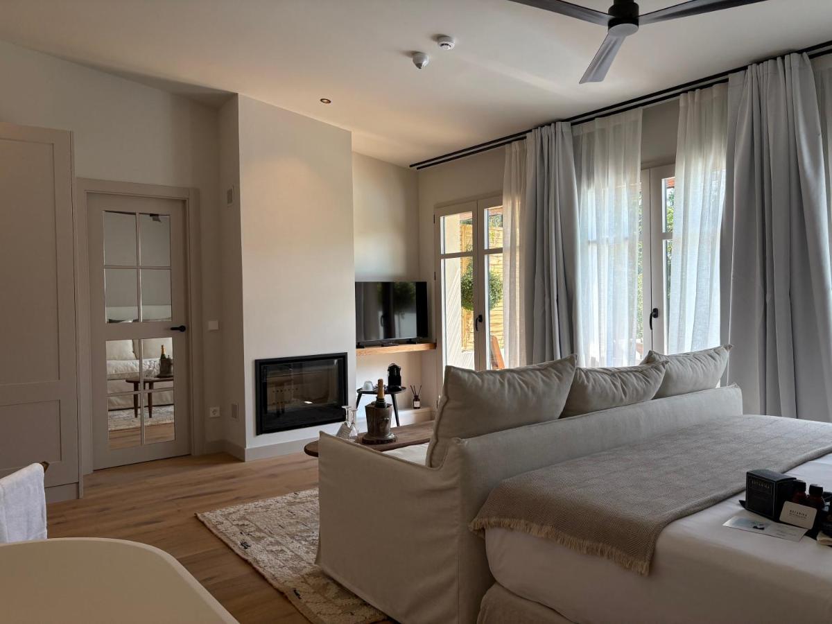 Una sala de estar con una cama blanca y un sofá. en Hotel La Malcontenta, en Palamós