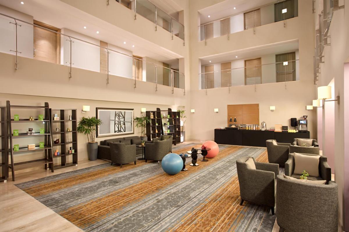 a large lobby with chairs and a waiting room at DoubleTree Suites by Hilton Bengaluru Outer Ring Road in Bengaluru