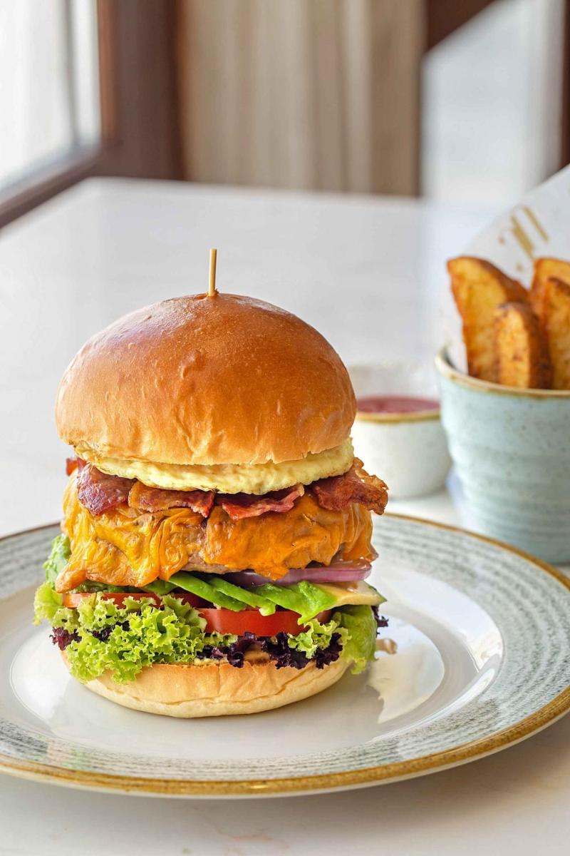 a sandwich on a plate on a table with french fries at Hyatt Regency Jaipur Mansarovar in Jaipur a sandwich on a plate on a table with french fries at Hyatt Regency Jaipur Mansarovar in Jaipur