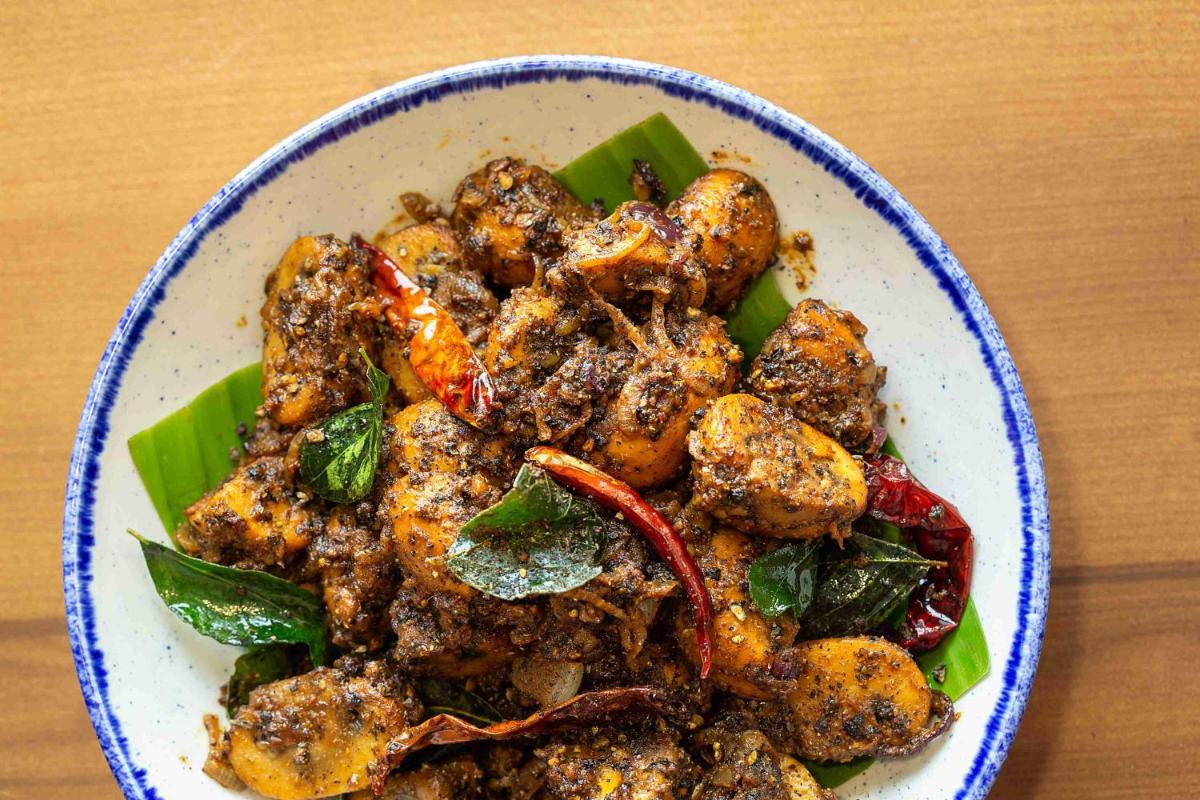 a bowl of food with shrimp and greens on a table at Hyatt Regency Jaipur Mansarovar in Jaipur a bowl of food with shrimp and greens on a table at Hyatt Regency Jaipur Mansarovar in Jaipur