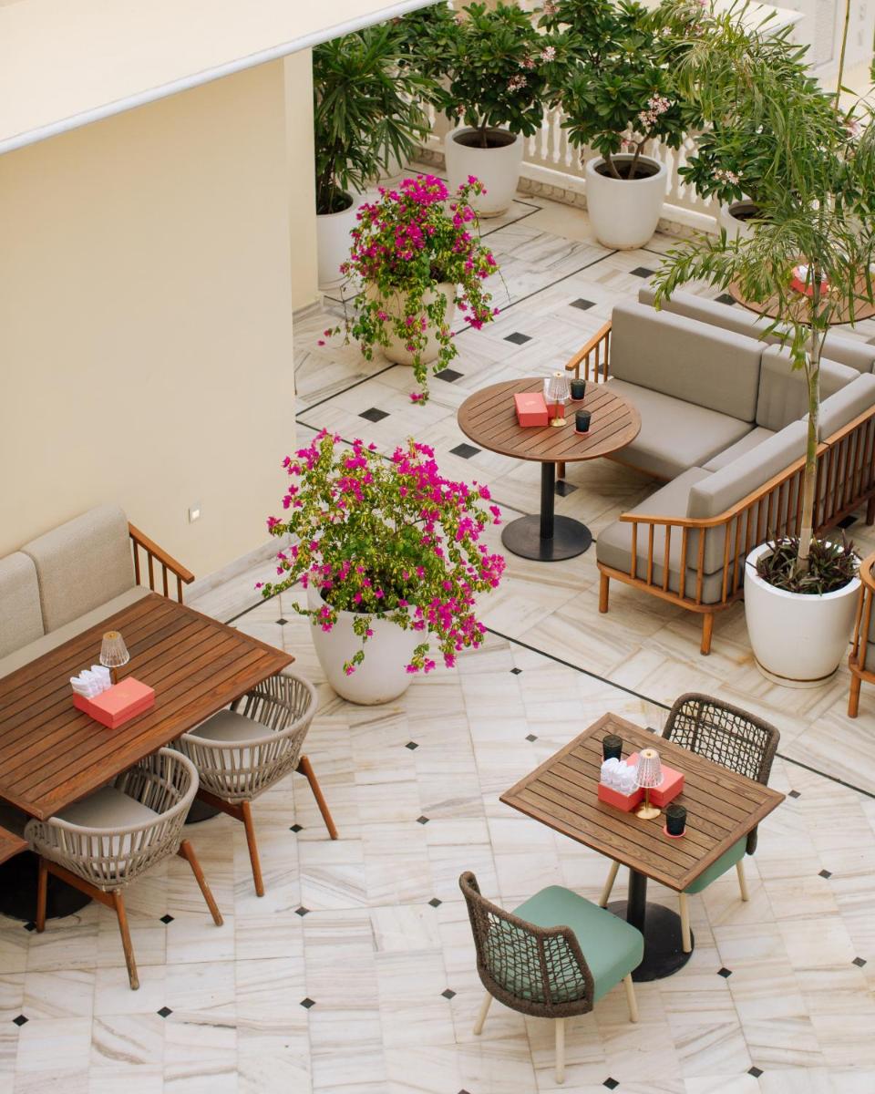 a patio with tables and chairs and potted plants at Hyatt Regency Jaipur Mansarovar in Jaipur a patio with tables and chairs and potted plants at Hyatt Regency Jaipur Mansarovar in Jaipur