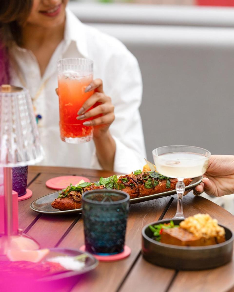 a woman sitting at a table with a plate of food at Hyatt Regency Jaipur Mansarovar in Jaipur a woman sitting at a table with a plate of food at Hyatt Regency Jaipur Mansarovar in Jaipur