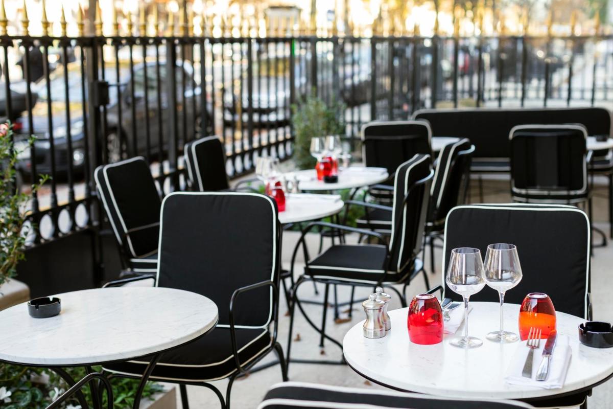 - une rangée de tables et de chaises avec des verres à vin dans l'établissement Hotel Montaigne, à Paris