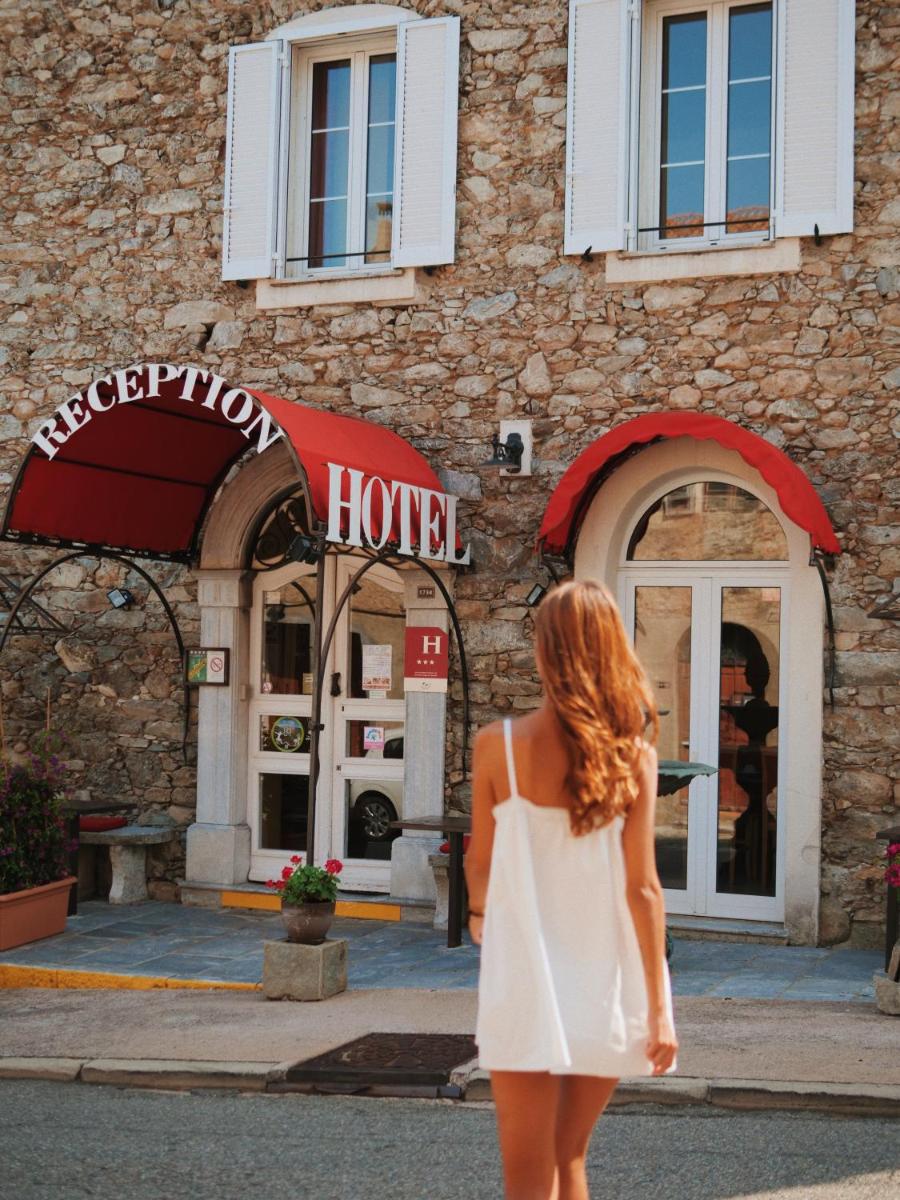 une femme en robe blanche marchant devant un bâtiment dans l'établissement Hôtel U Palazzu & Spa, à Venaco