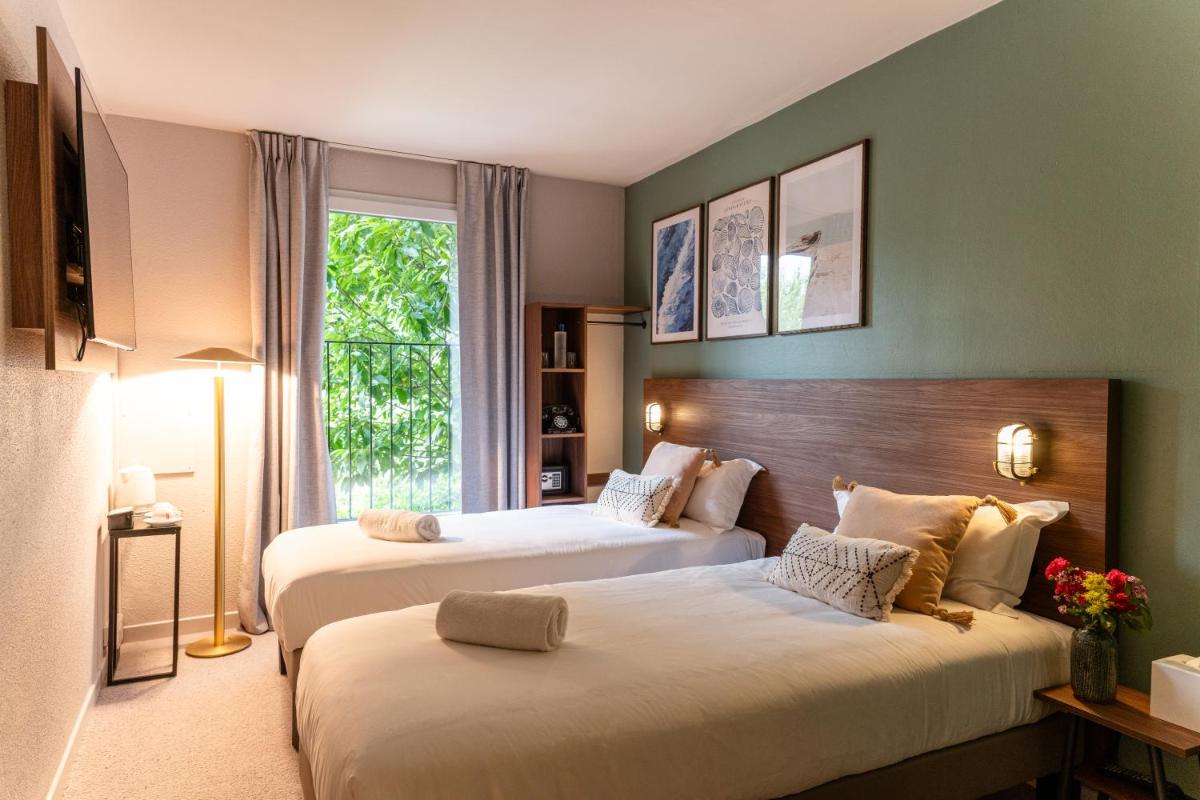 une chambre avec deux lits et une fenêtre dans l'établissement La Maison OBONO Hôtel & Spa, au Bono