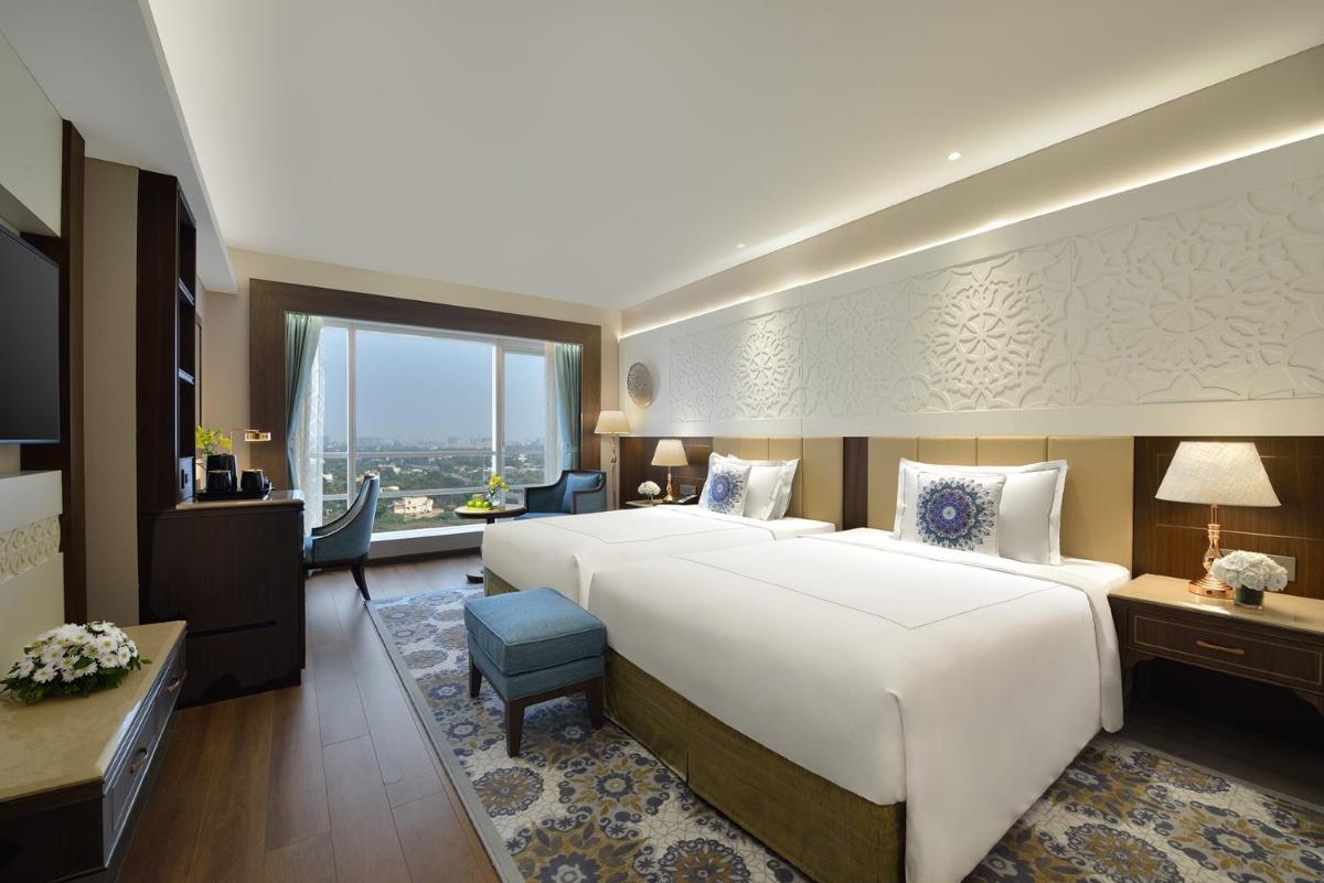 a large hotel room with a large bed and a desk at Taj Skyline Ahmedabad in Ahmedabad
