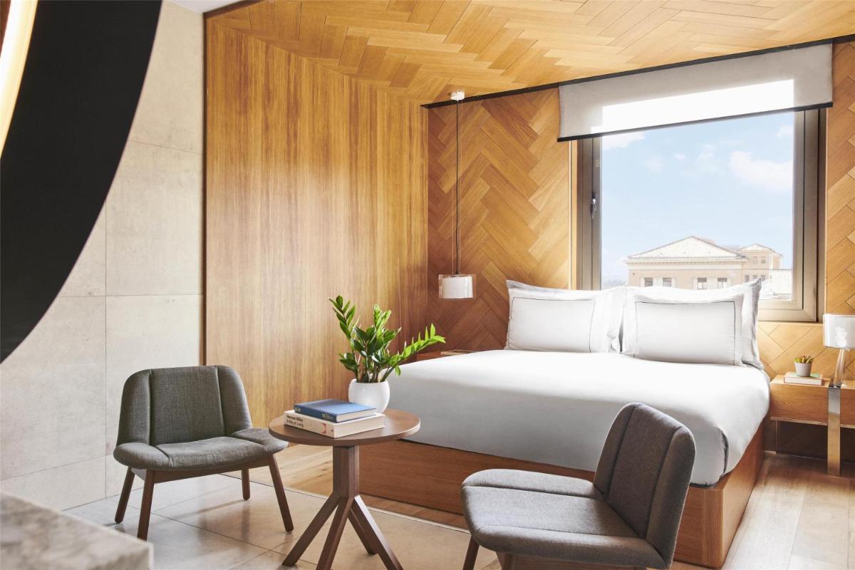 Un dormitorio con una cama y dos sillas y una ventana. en Grand Hyatt Barcelona, en Barcelona