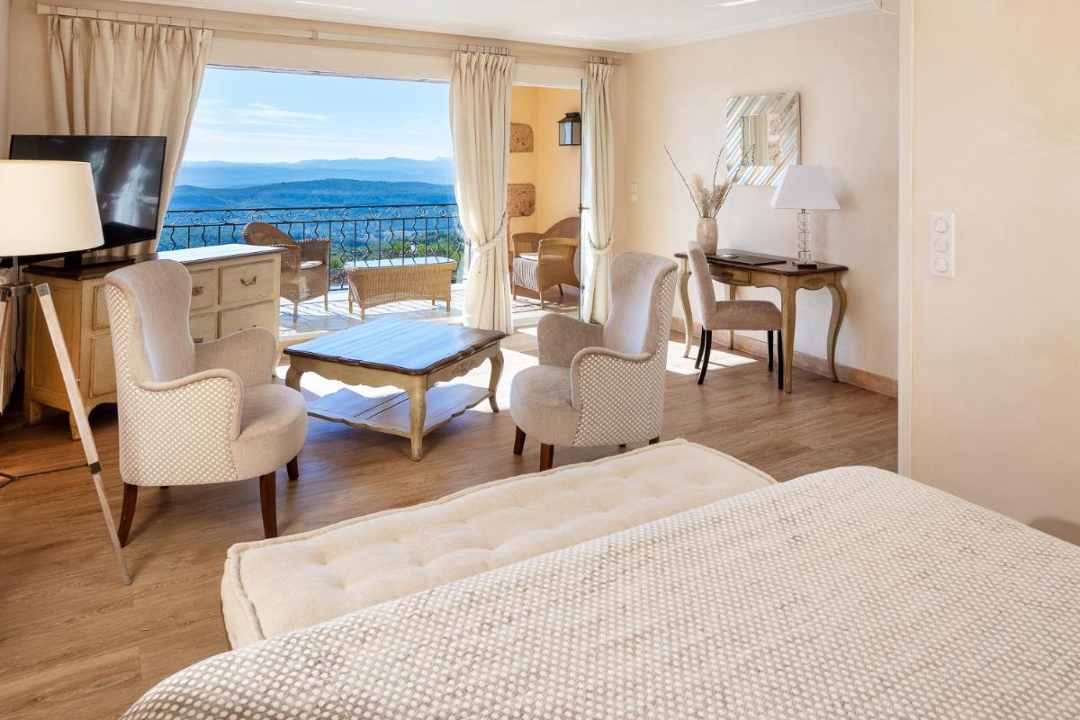 - une chambre avec un lit et un salon avec vue dans l'établissement La Bastide De Tourtour Hotel & Spa, à Tourtour