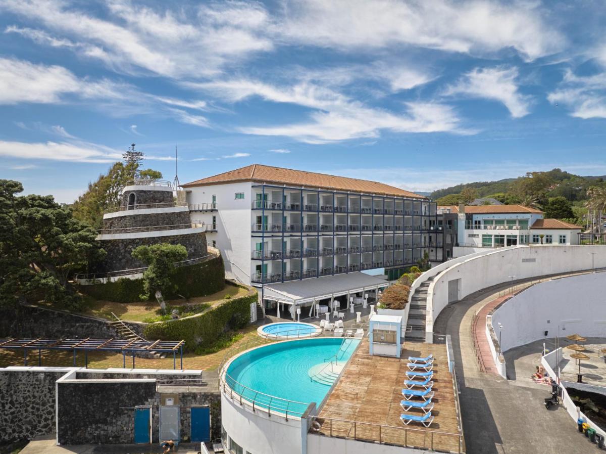 um resort com piscina e um prédio em Hotel Do Caracol em Angra do Heroísmo