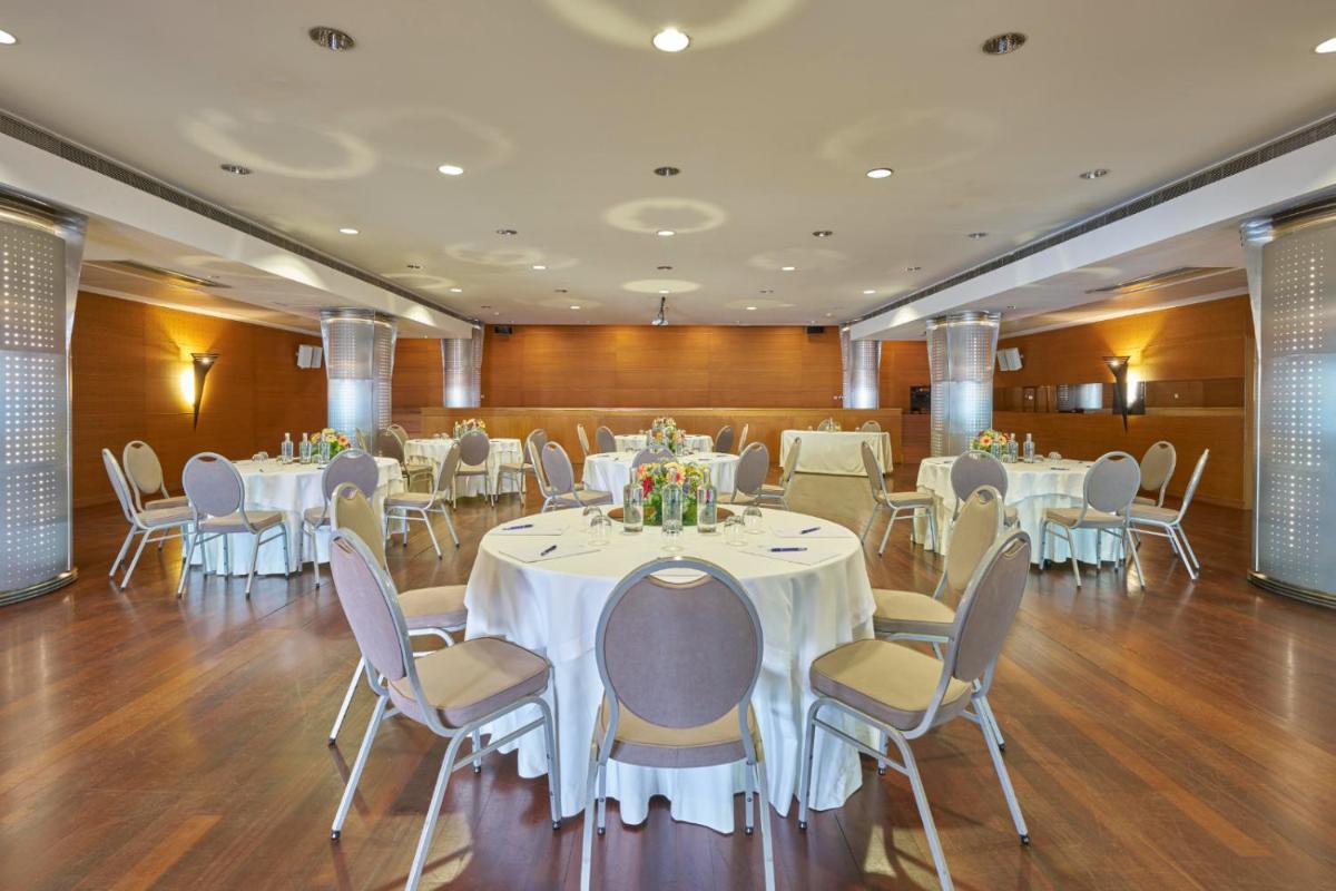 um salão de banquetes com mesas e cadeiras brancas em Hotel Do Caracol em Angra do Heroísmo mais 53 fotografias