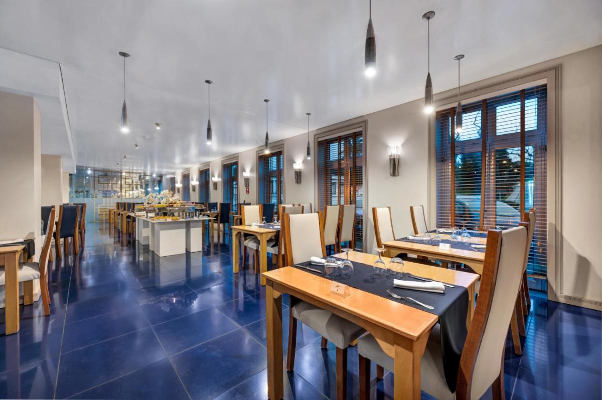 uma sala de jantar com mesas e cadeiras de madeira em Hotel Do Caracol em Angra do Heroísmo