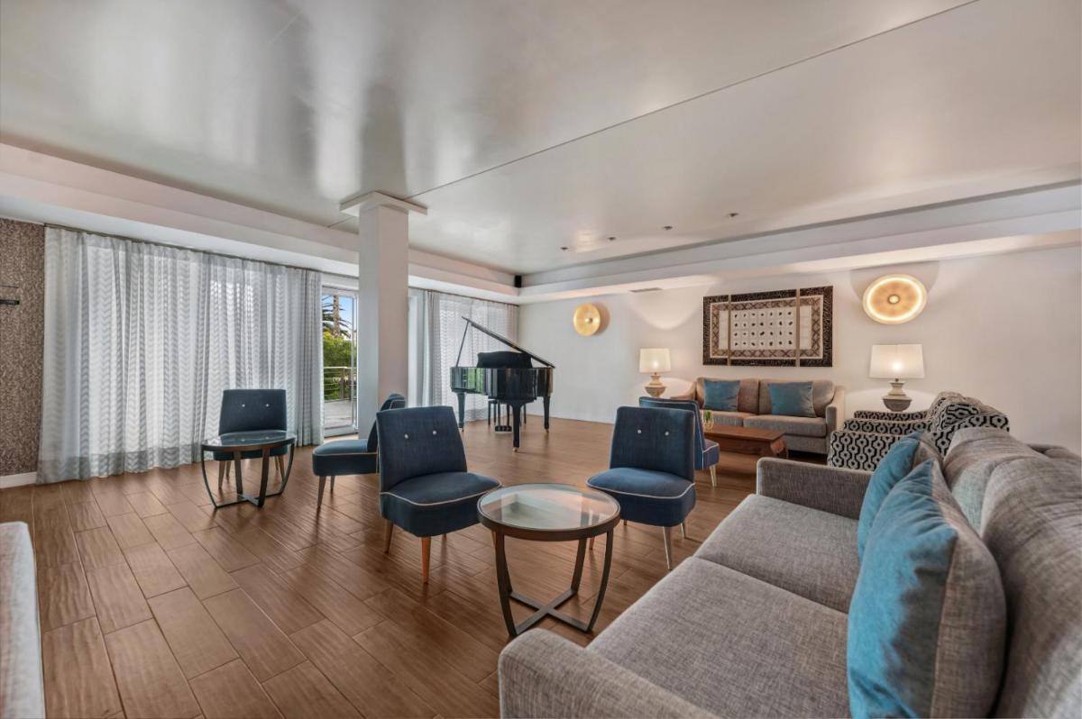 uma sala de estar com um sofá e um piano em Hotel Do Caracol em Angra do Heroísmo