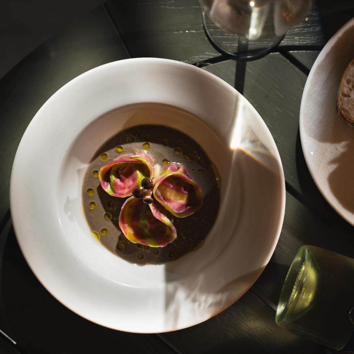 a white bowl with food in it on a table at Four Seasons Hotel Bengaluru at Embassy ONE in Bengaluru a white bowl with food in it on a table at Four Seasons Hotel Bengaluru at Embassy ONE in Bengaluru