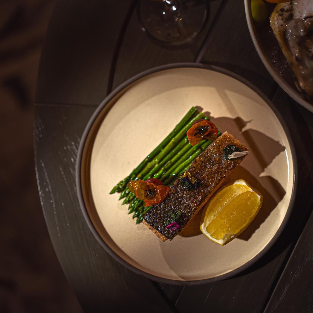 a plate of food with a slice of lemon at Four Seasons Hotel Bengaluru at Embassy ONE in Bengaluru a plate of food with a slice of lemon at Four Seasons Hotel Bengaluru at Embassy ONE in Bengaluru