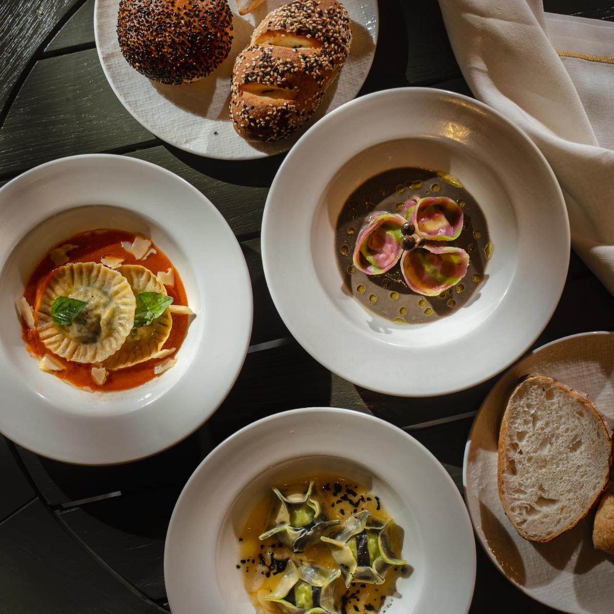 a table topped with bowls of soup and bread at Four Seasons Hotel Bengaluru at Embassy ONE in Bengaluru a table topped with bowls of soup and bread at Four Seasons Hotel Bengaluru at Embassy ONE in Bengaluru