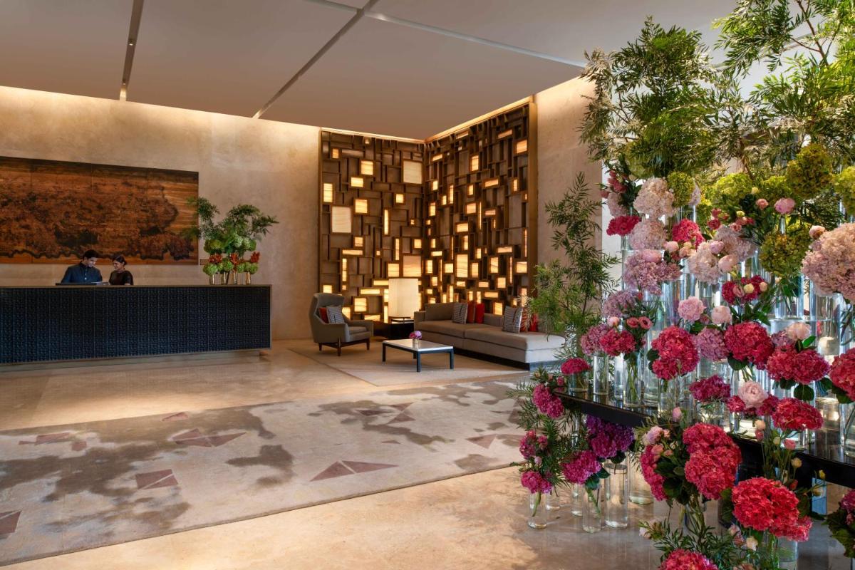a lobby with flowers in vases on the wall at Four Seasons Hotel Bengaluru at Embassy ONE in Bengaluru a lobby with flowers in vases on the wall at Four Seasons Hotel Bengaluru at Embassy ONE in Bengaluru